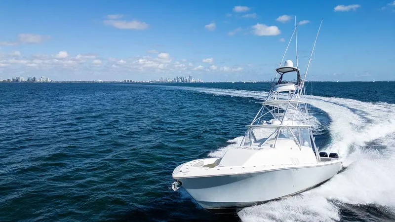 Slide: The Image of 2015 SeaVee 430 Fisharound cruising on open water, clear sky, city skyline in background. - 17