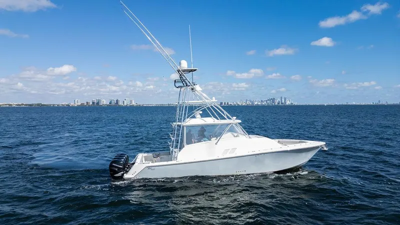 Slide: The Image of 2015 SeaVee 430 Fisharound boat cruising on open water under clear blue sky. - 2