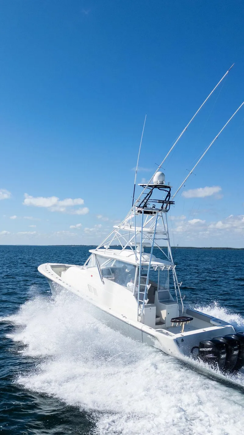Slide: The Image of 2015 SeaVee 430 Fisharound cruising on open water under clear blue skies. - 29