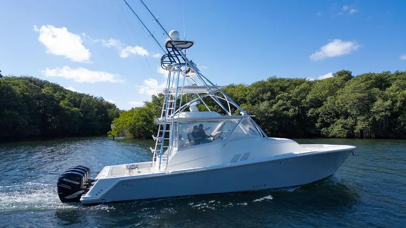 Slide: The Image of 2015 SeaVee 430 Fisharound boat cruising on a sunny day, surrounded by lush greenery. - 41