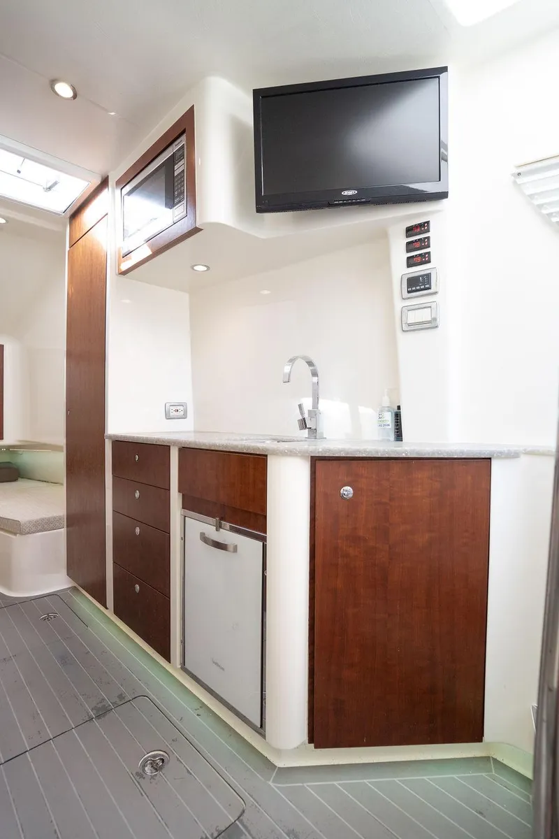 Slide: The Image of 2015 SeaVee 430 Fisharound interior with kitchenette, TV, and modern cabinetry. - 45