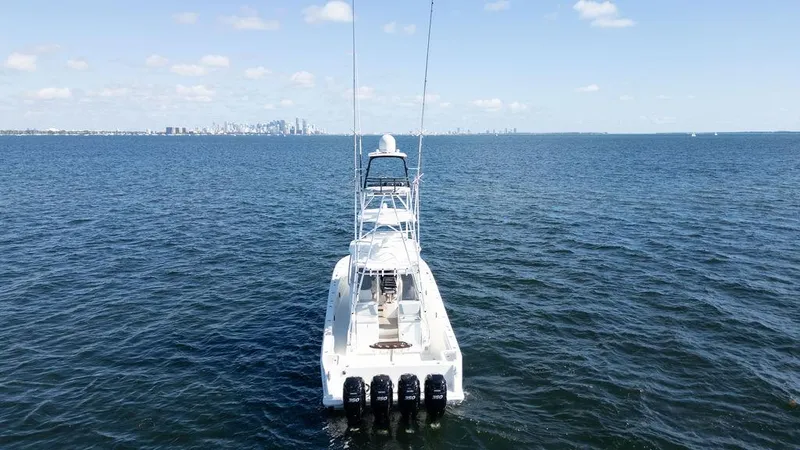 Slide: The Image of 2015 SeaVee 430 Fisharound boat on open water, distant city skyline. - 5