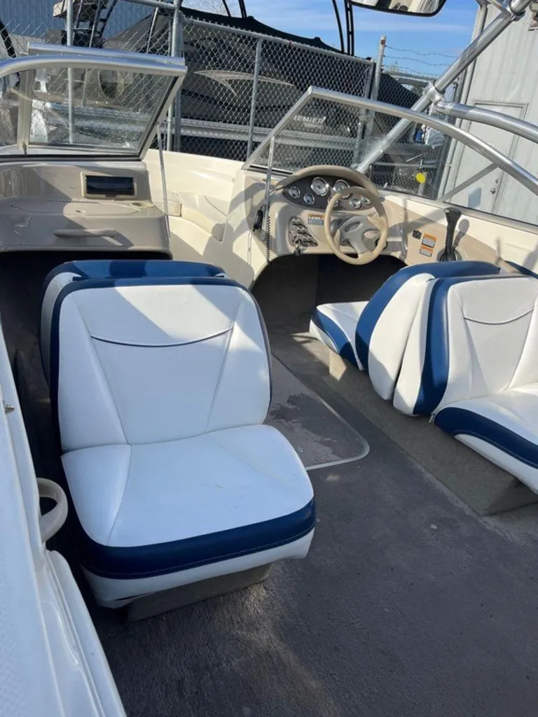 Slide: The Image of 2002 Bayliner 185 boat interior with white and blue seating, steering wheel, and dashboard. - 3