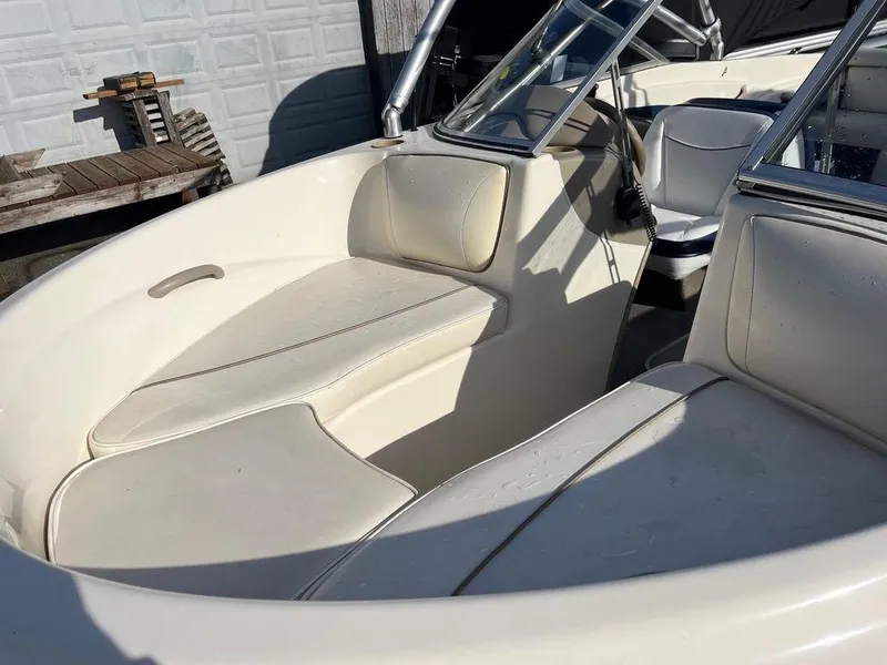 Slide: The Image of 2002 Bayliner 185 boat interior with white seating and steering wheel. - 5
