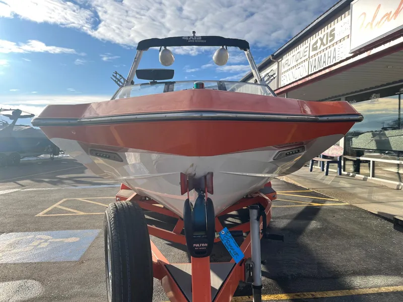 Slide: The Image of 2016 Axis Boats A22 on trailer, parked outdoors under a partly cloudy sky. - 10