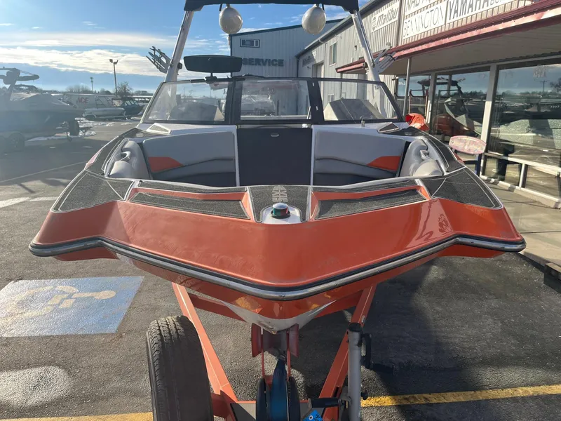 Slide: The Image of 2016 Axis Boats A22 in orange, parked outdoors on a trailer. - 11