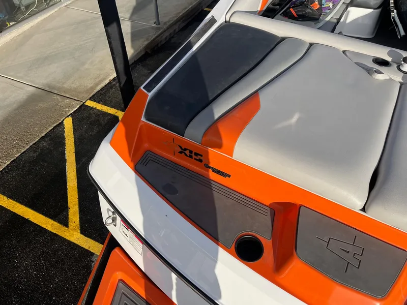 Slide: The Image of 2016 Axis Boats A22, orange and gray seating, docked on pavement. - 14