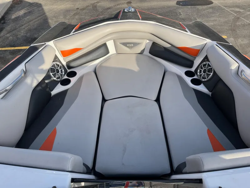 Slide: The Image of 2016 Axis Boats A22 interior with gray and orange seating, cup holders, and speakers. - 28