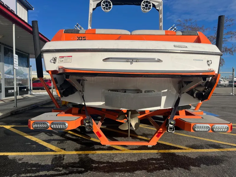 Slide: The Image of 2016 Axis Boats A22, orange and white, parked in a lot, rear view. - 5