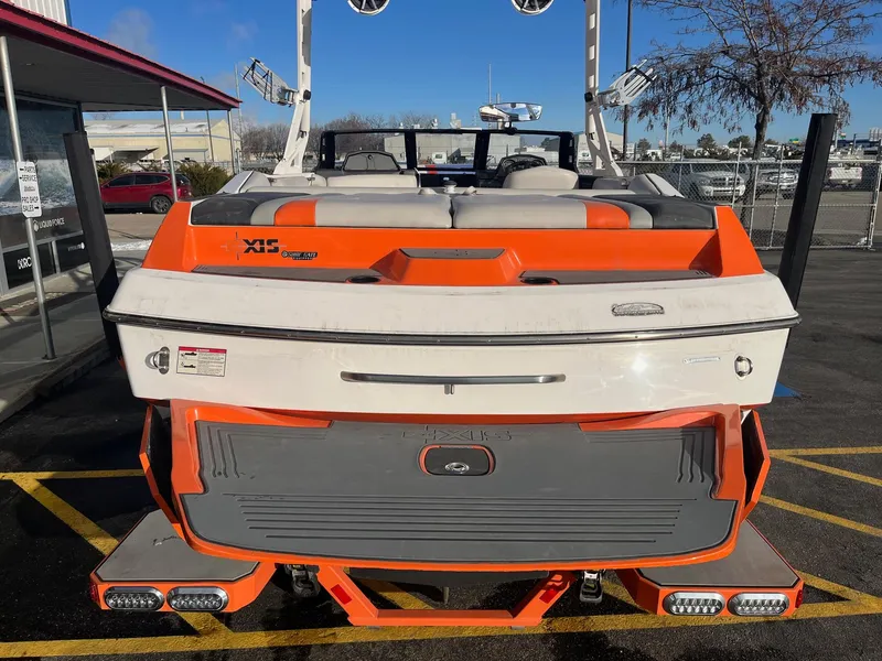 Slide: The Image of 2016 Axis Boats A22, orange and white, parked outdoors, rear view. - 6