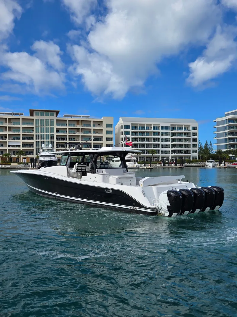 Slide: The Image of 2021 HCB 65 Estrella boat on water, modern buildings in background, clear blue sky. - 11