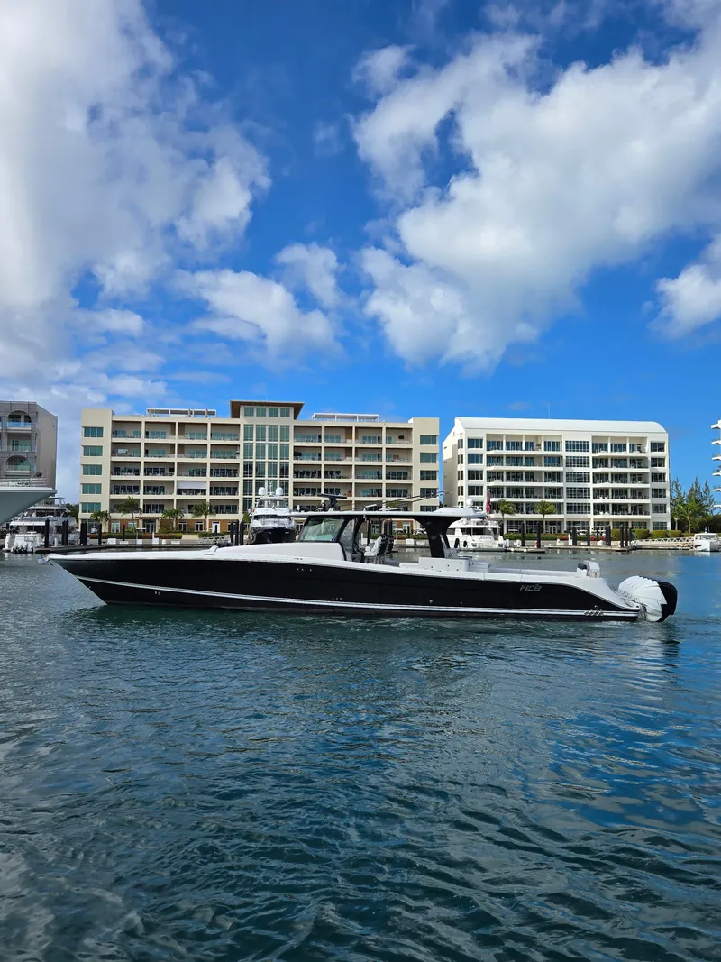 Slide: The Image of 2021 HCB 65 Estrella boat docked near modern waterfront buildings. - 13
