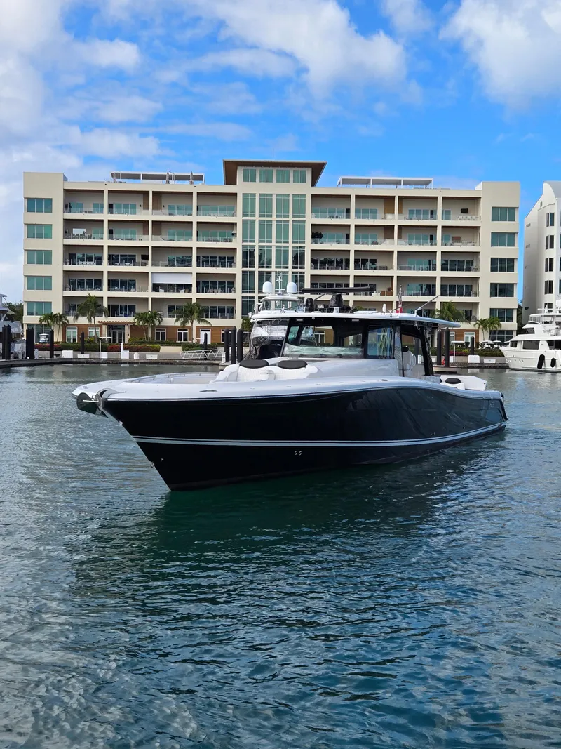 Slide: The Image of 2021 HCB 65 Estrella yacht in marina, modern building backdrop, clear sky. - 16