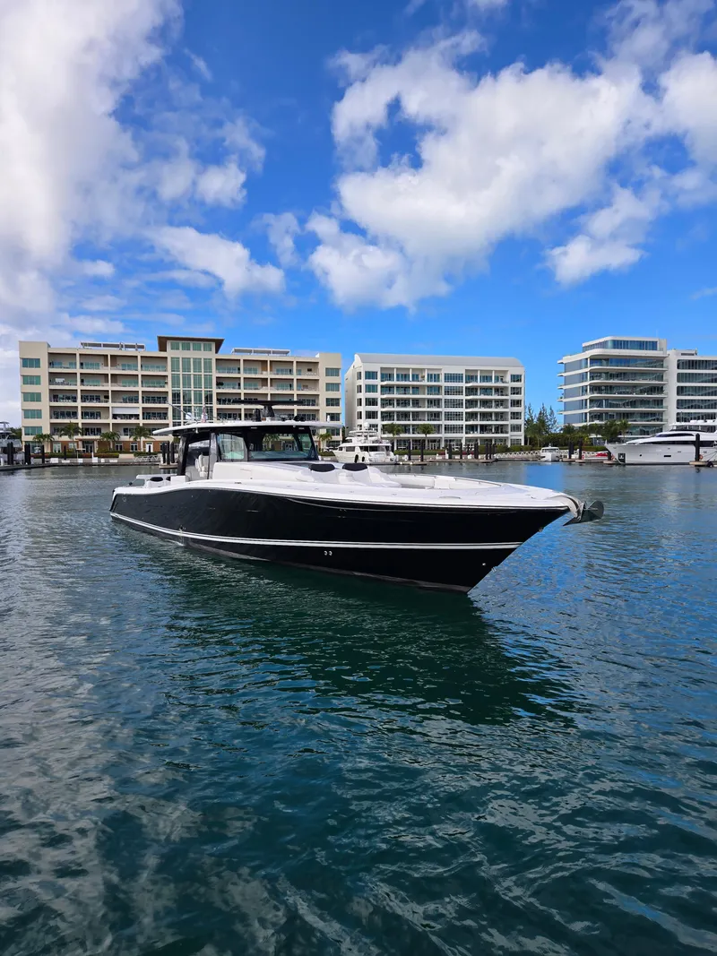 Slide: The Image of 2021 HCB 65 Estrella boat on water with modern buildings in background. - 18