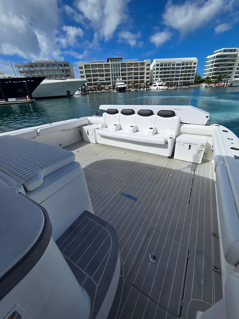 Slide: The Image of 2021 HCB 65 Estrella boat deck with seating, docked near modern buildings. - 19