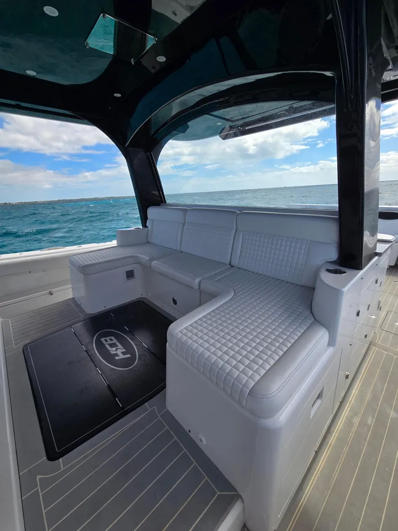 Slide: The Image of 2021 HCB 65 Estrella luxury boat interior with white seating and ocean view. - 23
