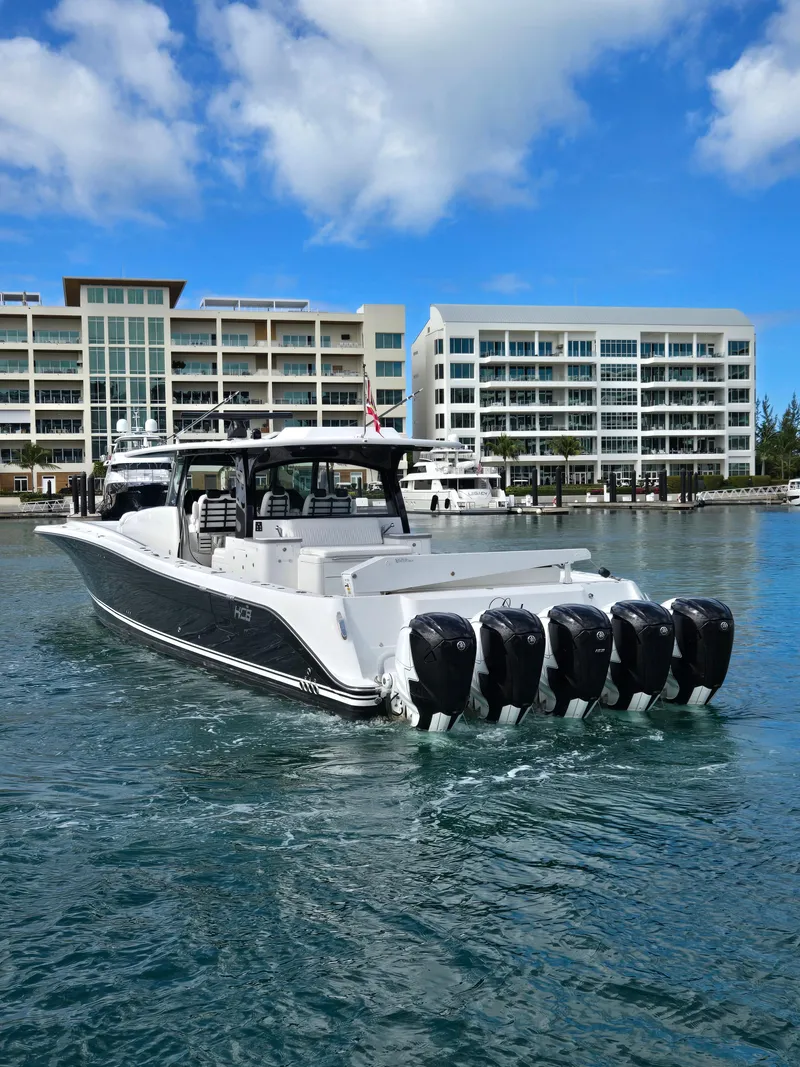 Slide: The Image of 2021 HCB 65 Estrella boat with multiple engines docked near modern buildings. - 24