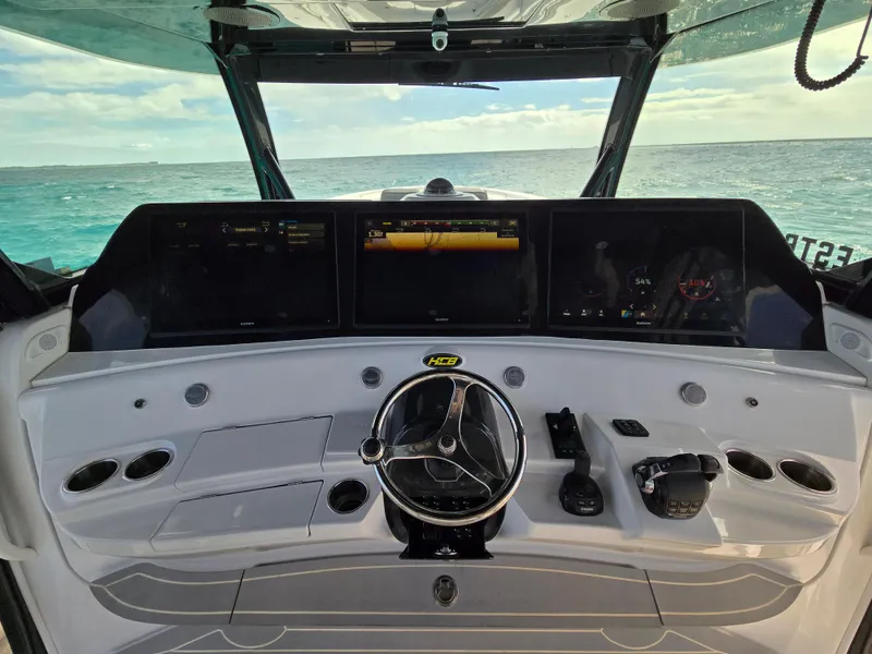 Slide: The Image of 2021 HCB 65 Estrella helm with advanced navigation screens and controls, overlooking the ocean. - 29