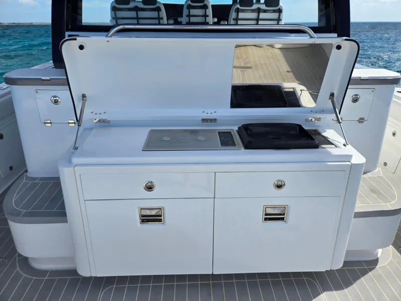 Slide: The Image of 2021 HCB 65 Estrella boat kitchen with stove and storage, ocean view in background. - 31