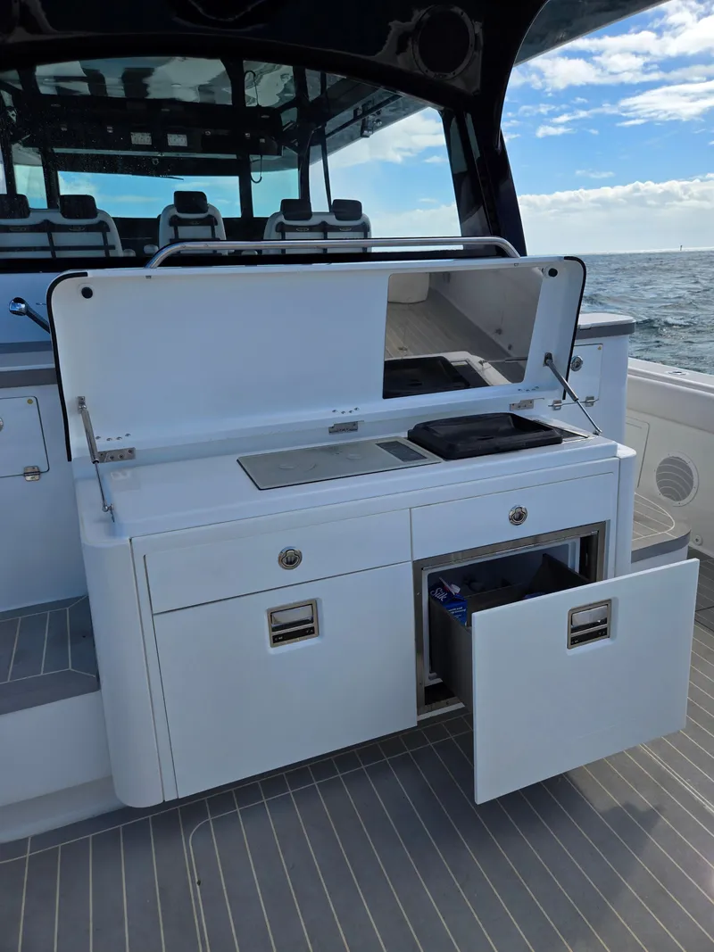 Slide: The Image of 2021 HCB 65 Estrella yacht with open storage compartments and seating area. - 32