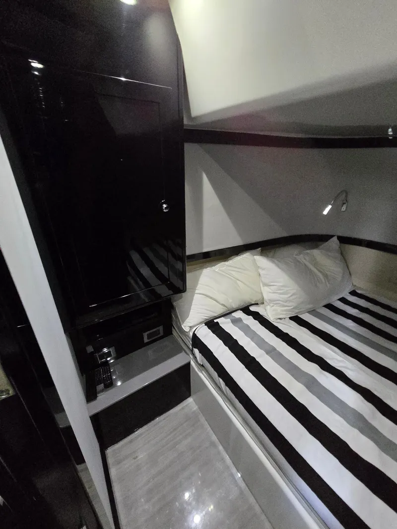 Slide: The Image of 2021 HCB 65 Estrella cabin interior with striped bedding and sleek black cabinetry. - 40