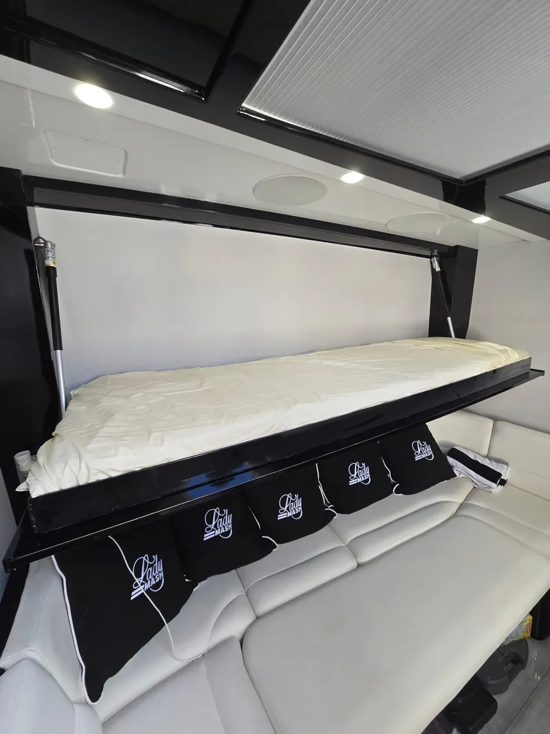 Slide: The Image of Interior of 2021 HCB 65 Estrella with a fold-down bed and cushioned seating. - 46