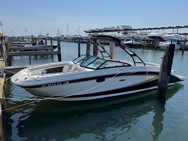 Slide: The Image of 2016 Sea Ray SDX 270 boat docked in a marina, calm water, clear sky. - 1