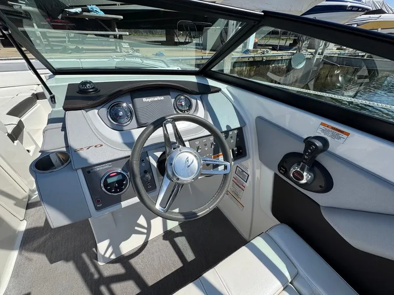 Slide: The Image of 2016 Sea Ray SDX 270 boat cockpit with steering wheel and control panel. - 12