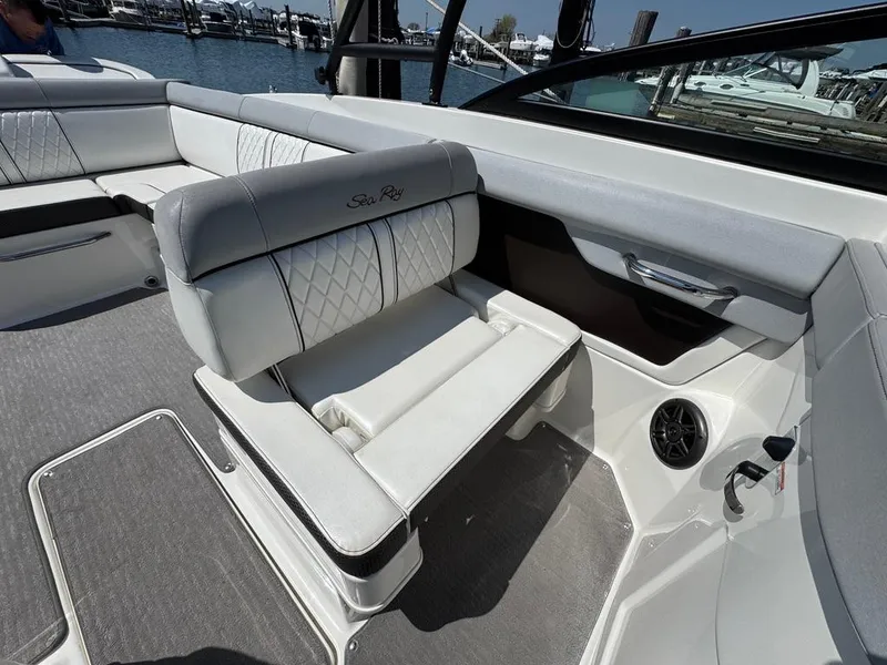 Slide: The Image of 2016 Sea Ray SDX 270 boat interior with white seating and speaker, docked at marina. - 20