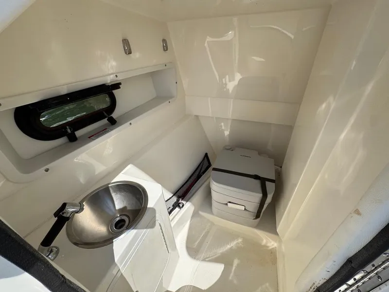 Slide: The Image of 2016 Sea Ray SDX 270 boat interior with sink and portable toilet. - 23