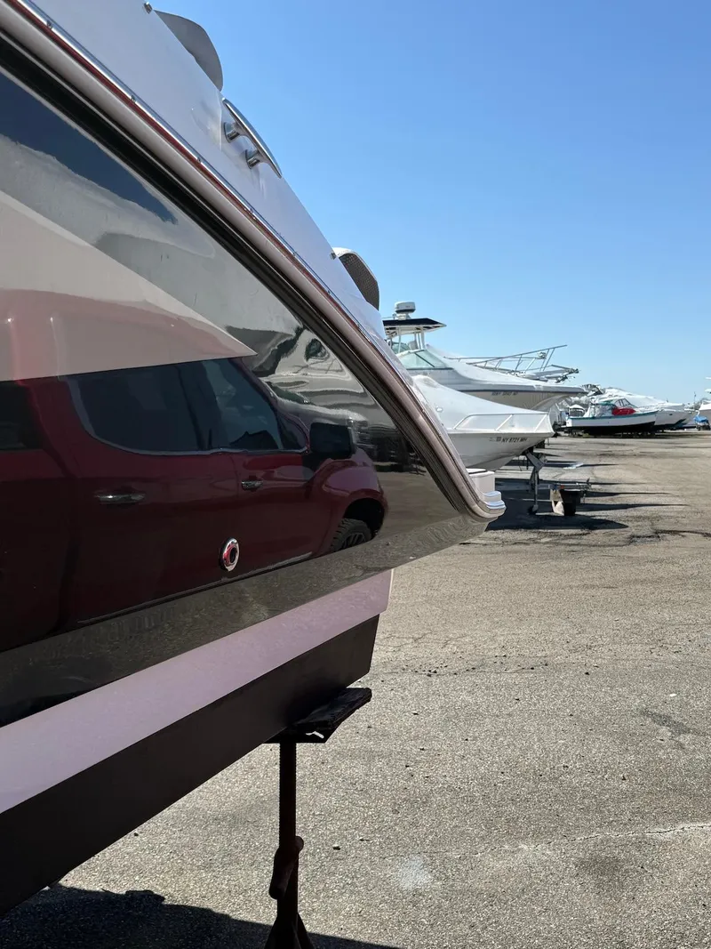 Slide: The Image of 2016 Sea Ray SDX 270 boat in a marina, side view under clear blue sky. - 24