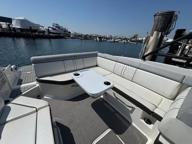 Slide: The Image of 2016 Sea Ray SDX 270 boat interior with seating and table, docked at marina. - 8