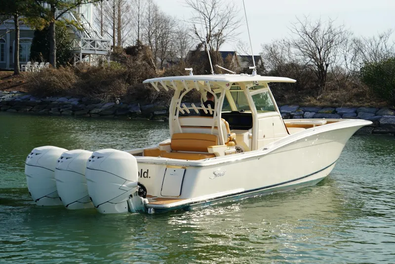 Slide: The Image of 2016 Scout 350 LXF boat with triple outboard engines on calm water. - 12