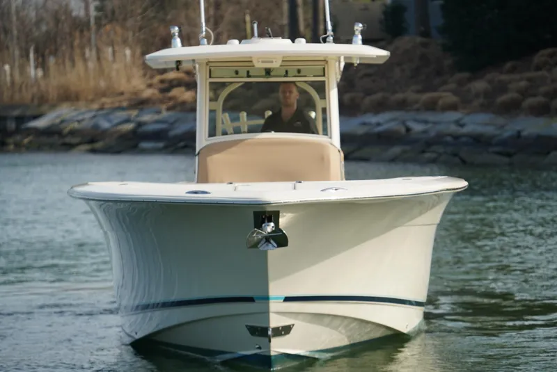 Slide: The Image of 2016 Scout 350 LXF boat on water, front view, with a person at the helm. - 16