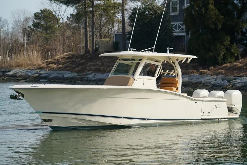Slide: The Image of 2016 Scout 350 LXF boat on calm water, featuring sleek design and twin engines. - 18