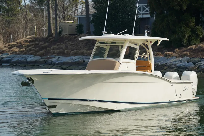 Slide: The Image of 2016 Scout 350 LXF boat on calm water, featuring sleek design and twin engines. - 19