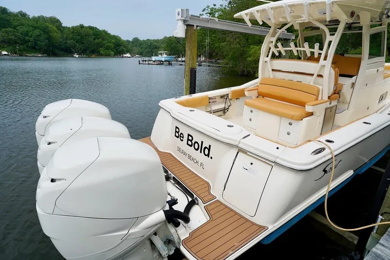 Slide: The Image of 2016 Scout 350 LXF boat docked with triple engines, featuring "Be Bold" text on the stern. - 2