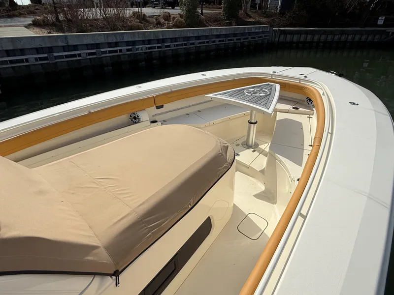 Slide: The Image of 2016 Scout 350 LXF boat with beige seating and a triangular table on deck. - 24