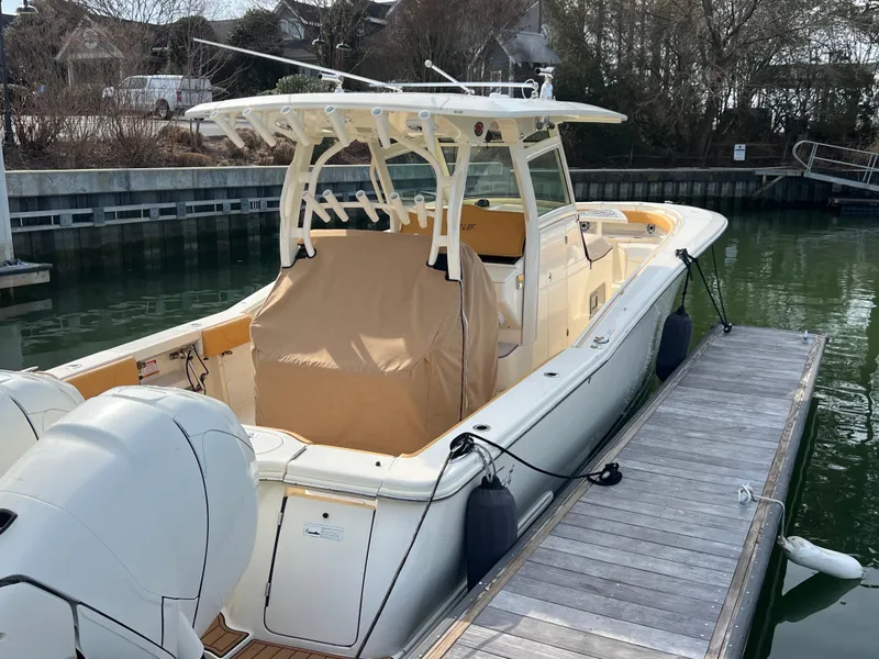 Slide: The Image of 2016 Scout 350 LXF boat docked, featuring dual engines and a covered seating area. - 26