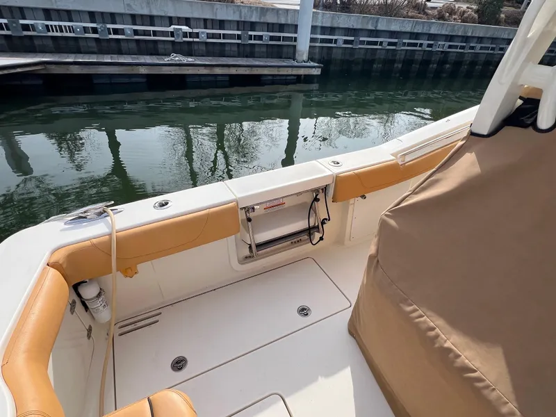 Slide: The Image of 2016 Scout 350 LXF boat interior with tan seating, docked by calm water. - 29