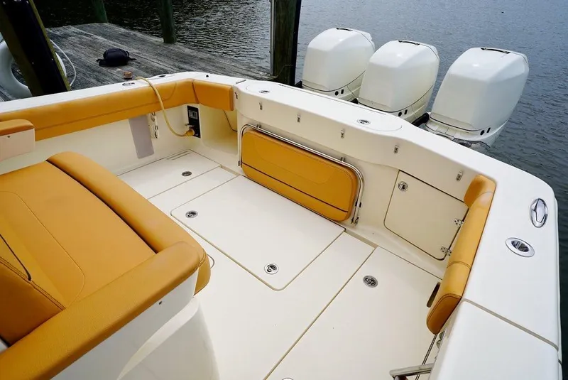 Slide: The Image of 2016 Scout 350 LXF boat interior with tan seating and triple outboard engines. - 3