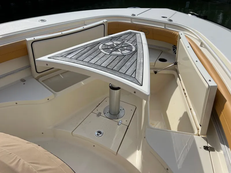 Slide: The Image of 2016 Scout 350 LXF boat interior with triangular table and seating area. - 38