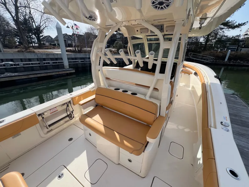 Slide: The Image of 2016 Scout 350 LXF boat interior with tan seating and fishing rod holders. - 42