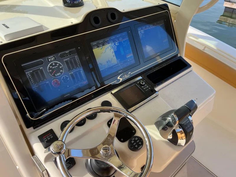 Slide: The Image of Control panel of a 2016 Scout 350 LXF boat with navigation screens and steering wheel. - 48