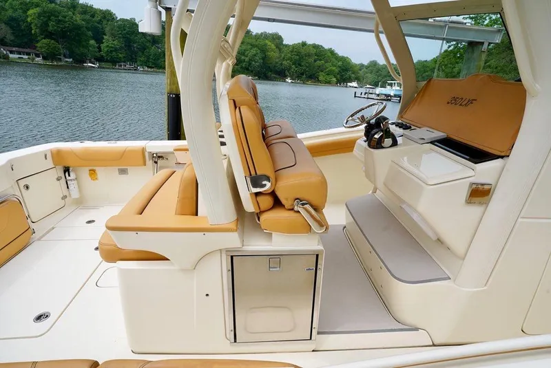 Slide: The Image of 2016 Scout 350 LXF boat interior with tan seating, helm, and water view. - 6