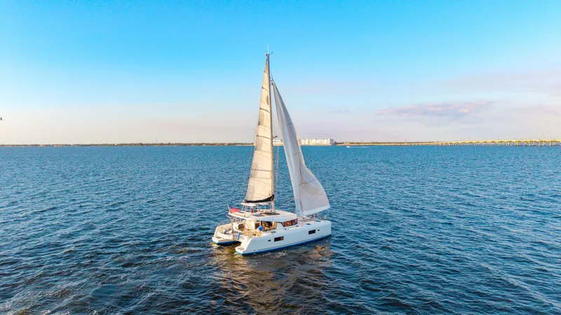 Slide: The Image of 2019 Lagoon 42 catamaran sailing on open water under clear blue skies. - 1
