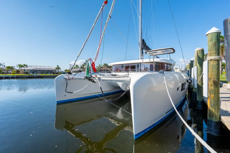 Slide: The Image of 2019 Lagoon 42 catamaran docked in a sunny marina. - 10