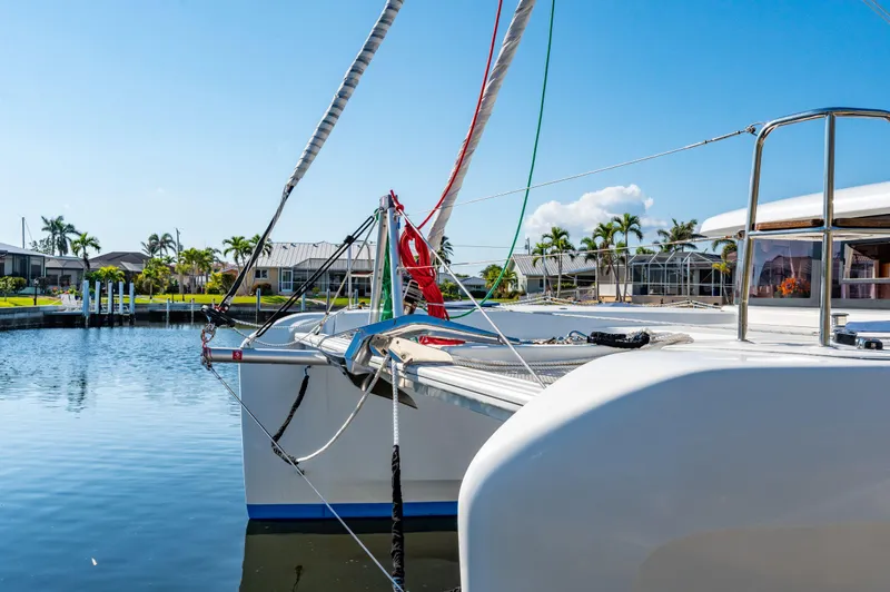 Slide: The Image of 2019 Lagoon 42 catamaran docked in a sunny marina with palm trees. - 12