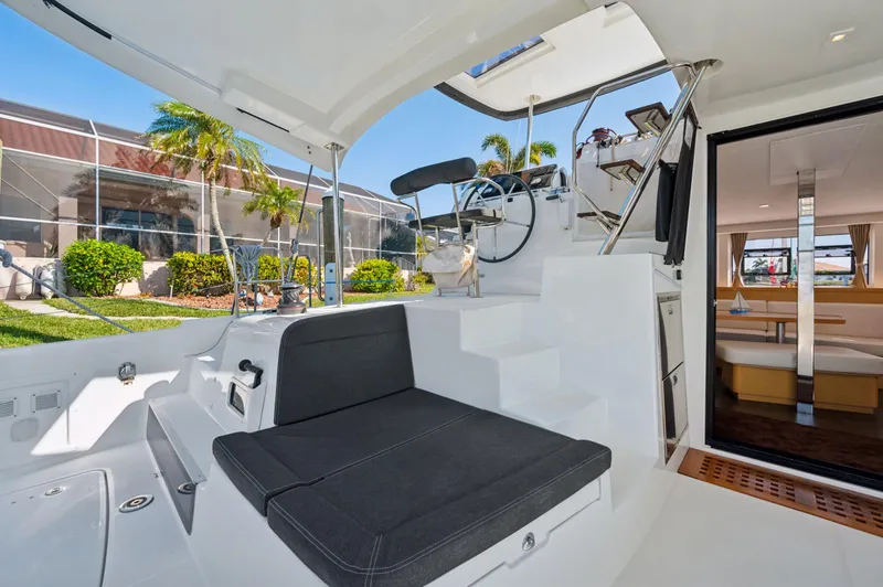 Slide: The Image of 2019 Lagoon 42 yacht interior with seating, steering wheel, and cabin view. - 13