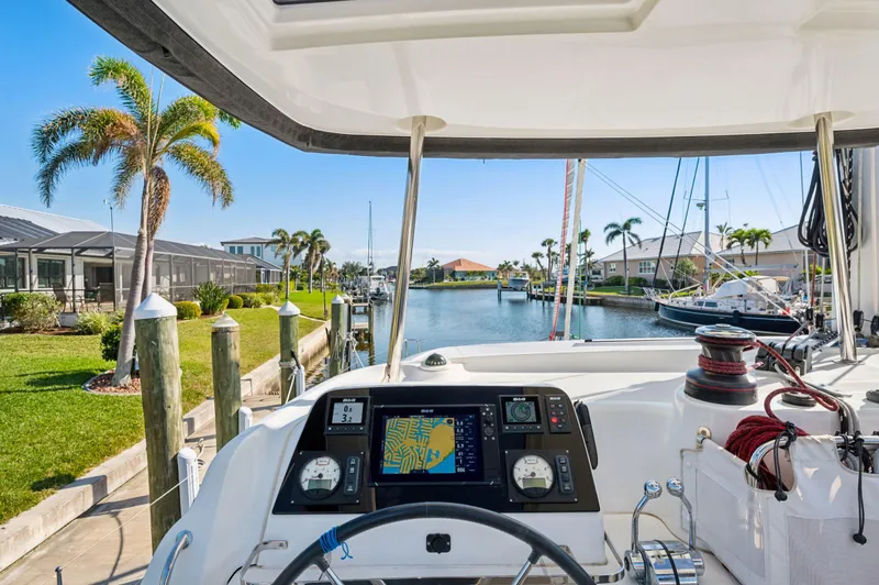 Slide: The Image of Cockpit view of 2019 Lagoon 42 catamaran docked in a sunny marina. - 16